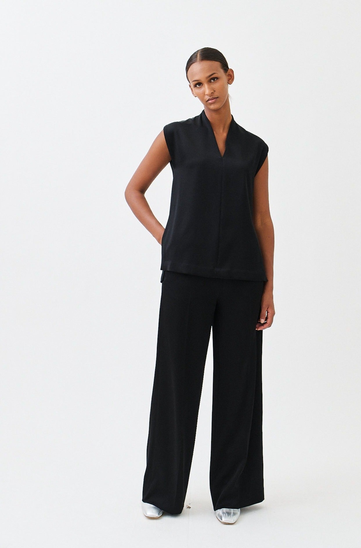 wingate collection taru black top on female model with silver boots dynamic